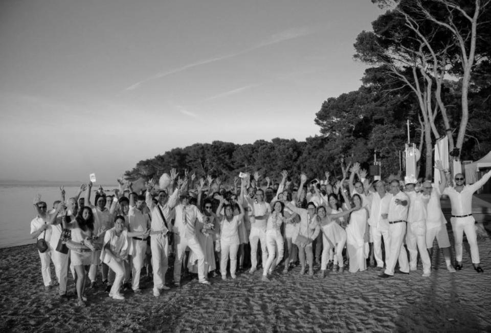 Black and white photograph of the whole Aromatech team on a beach